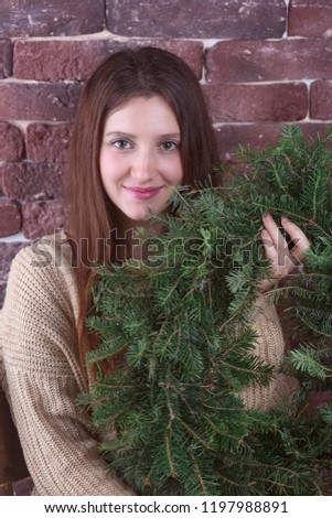 beautiful woman holding christmas wreath
