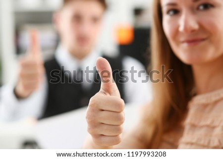 Beautiful smiling woman showing OK or approval sign with thumb up in creative people office closeup. High level and quality service job offer excellent education advisor serious business concept