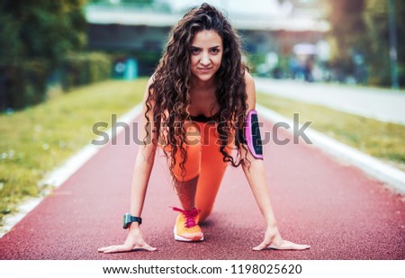 Ready to run. Athlete woman in starting run position. Sport, fitness, athletics concept