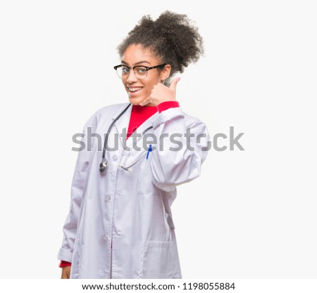 Young afro american doctor woman over isolated background smiling doing phone gesture with hand and fingers like talking on the telephone. Communicating concepts.