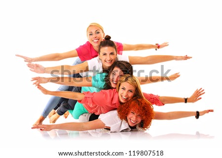 A picture of five joyful girls lying on each other and smiling over white background