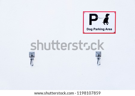 Dog parking area sign and hooks for tied up pet on leash or lead for safety and rest