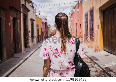 Girl in a flower dress walking trough the streets of San Miguel De Allende in Guanajuato, México.