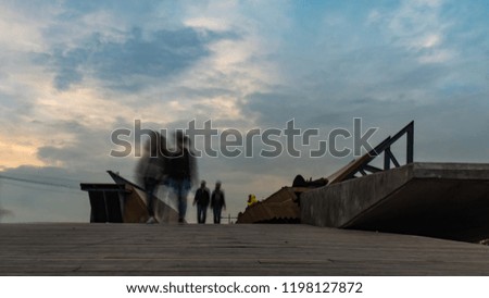 Turkey, izmir city at sunset with blurred people walking on the bridge. Long exposure image. Travel, tourism and architecture concepts.