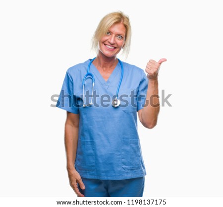 Middle age blonde nurse surgeon doctor woman over isolated background doing happy thumbs up gesture with hand. Approving expression looking at the camera with showing success.