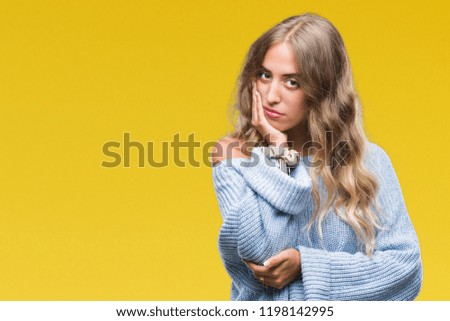 Beautiful young blonde woman wearing winter sweater over isolated background thinking looking tired and bored with depression problems with crossed arms.