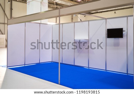 Exhibition stand design equipment. Booth template, Empty exhibition kiosk, with copy space, futuristic interior suspending lighting fixtures, shelves and tv screen.
