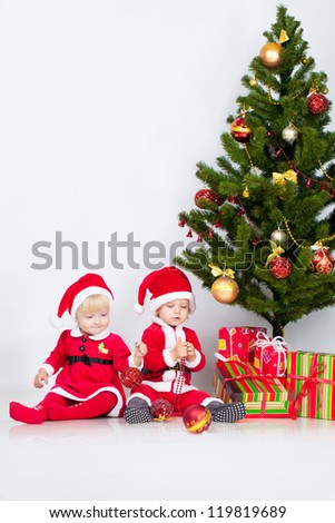 Two children sifting under christmas pine