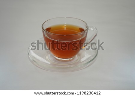 A cup of hot tea on white table.