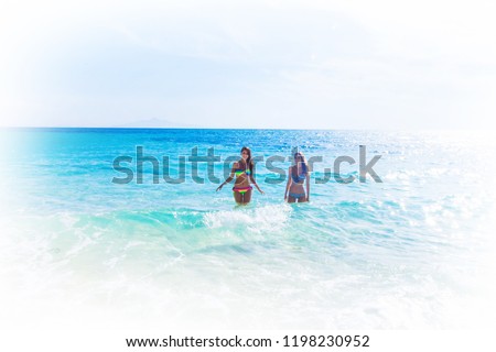 Beautiful fit women in bikni run on tropical beach