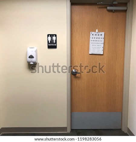 Gender neutral restroom door in a medical clinic with an eye chart on the door, Waterloo, Iowa