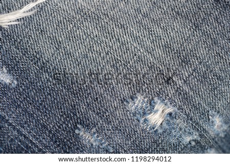Old torn blue jeans texture and background close up