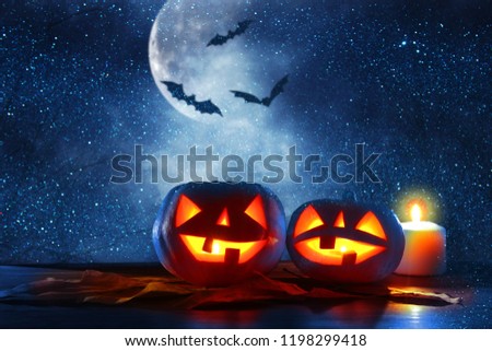 Halloween holiday concept. Pumpkins over wooden table at night scary, haunted and misty forest