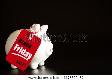 Shopping sale concept with red ticket Black Friday Sale tag hanging with piggy bank.