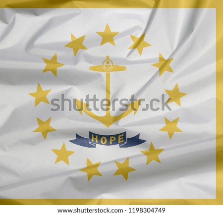 Fabric flag of Rhode Island. Crease of Rhode Island flag background, The states of America, Gold anchor, surrounded by 13 gold stars. A blue ribbon below the anchor contains the text "hope".