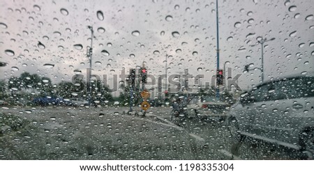 selective focus of rain drop on a car window with blurry background. 