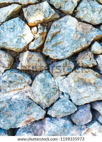 Texture, background, wall of large natural, untreated stones. Studio Photo