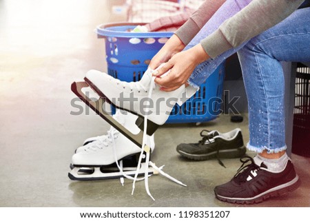 Woman laces figure skates in the sports shop