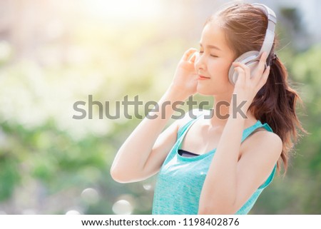 asian cute beautiful teen listening music with wireless headphone sport healthy dress enjoy smiling