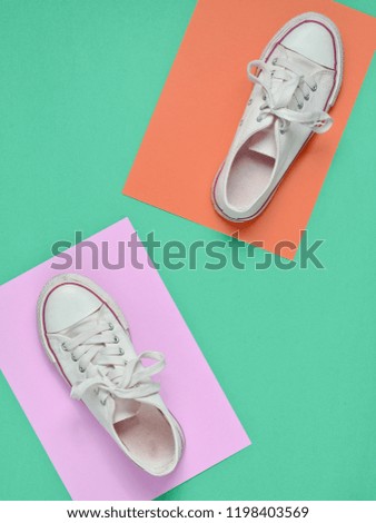 Retro sneakers step on a colored paper background. Top view.
