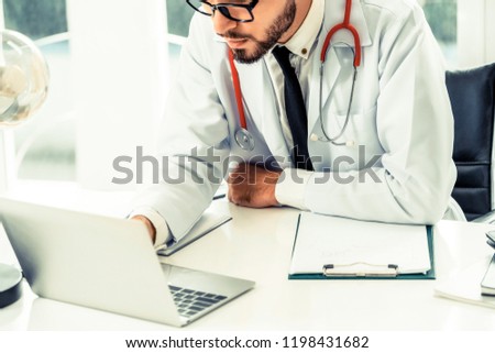 Doctor working on laptop computer at office table in the hospital. Medical and healthcare concept.