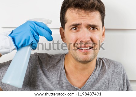 Young husband in crisis housework. Close up of stressed man with cleaning equipment