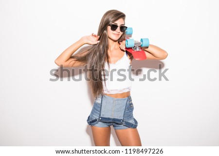 Smiling girl in sunglasses holding skateboard isolated on white background