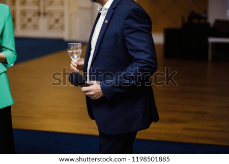 Champagne toast. Handsome elegant business man with glass of champagne at festive event.
