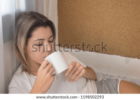 Very young girl drinking coffee in bed