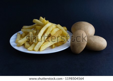 Potato fry or fries on dark background with selective focus and crop fragment