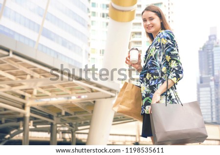 Beautiful women is holding shopping bag after shopping from department store on holiday