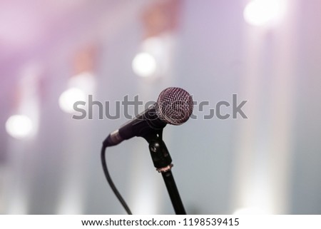 A microphone on stage in a concert hall or american bar (restaurant) during a show. 