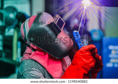 Industrial business concept with technician focus on welding process with equipment protective mask welder, leather gloves, PPE at construction site
