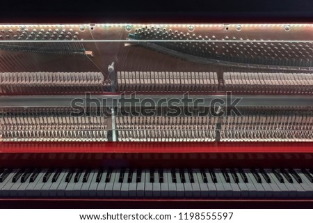 Piano with glass front cover. Piano keys and piano inside. Piano interior detail.