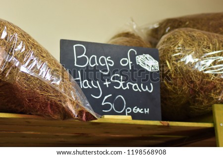 Bags of hay straw on sale for 50p on a farm.