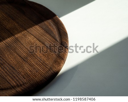 lines of sunlight and shadows on the surface; wooden texture and white background; play of light; equal division into two parts; geometry of lines of natural light; space for text
