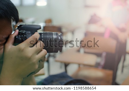 Blurred background of a man taking photographs with light flare from the right upper corner