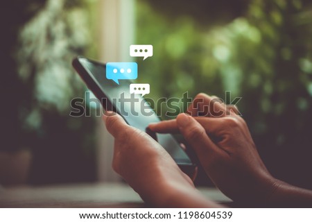 Women hand using smartphone typing, chatting conversation working home in chat box icons pop up. Social media maketing technology concept.Vintage soft color tone background. Royalty-Free Stock Photo #1198604539