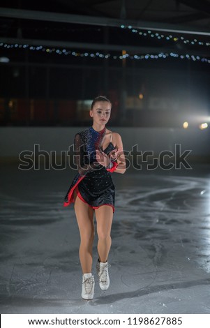 A beautiful young ice skater is enjoyin ice skating.