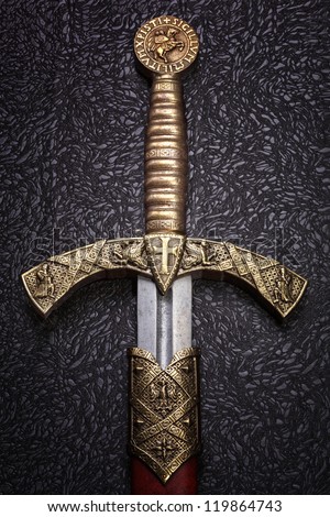Ancient sword with the bronze handhold on a  beautiful dark background Royalty-Free Stock Photo #119864743