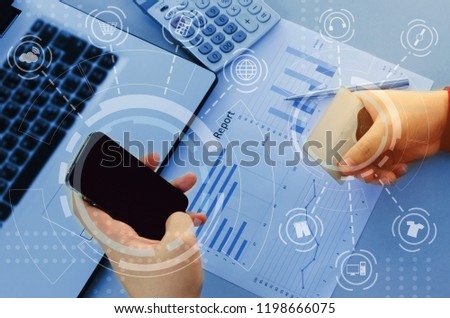 young man entering security code with smart phone and paying with credit card and laptop computer on desk at home office with graphic icon diagram, payment and shopping online, technology concept