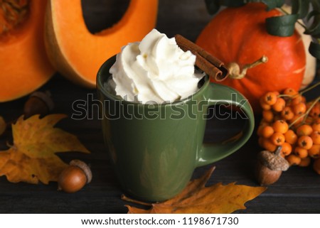 Composition with pumpkin spice latte  in cup on wooden table