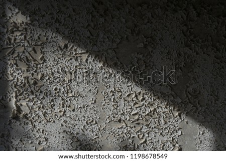 An old pebbled wall, a peeling and moldy color that creates an interesting abstract look.