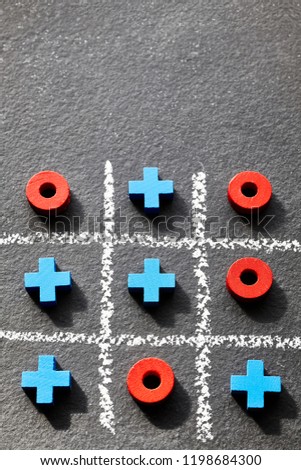 Close up picture of tic tac toe game (noughts and crosses) on dark background, selective focus.