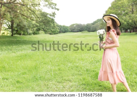 attractive asian female holding a white flower bouquet on nature background, she relax and feeling happy, vintage style