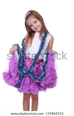 Cheerful young girl wearing white top and bright purple tutu skirt and artificial tinsel,isolated