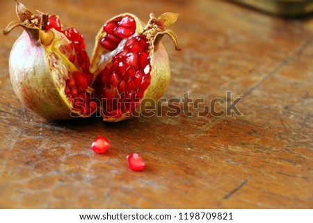 Ripe pomegranate fruit on wooden vintage background.Healthy food. Royalty-Free Stock Photo #1198709821