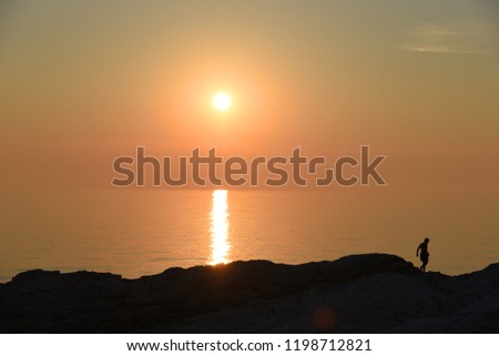 Beautiful sunset on the sea with tiny silhouette