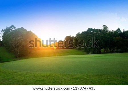 Flag on green golf in the evening golf course with sunshine in thailand