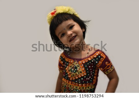Cute Indian baby girl dresses in traditional clothes and giving some natural poses.